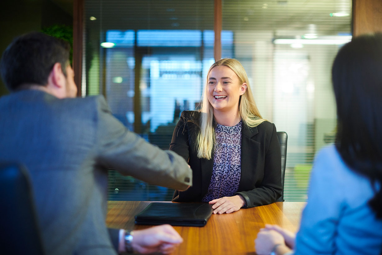 Woman shaking hands in a job interview