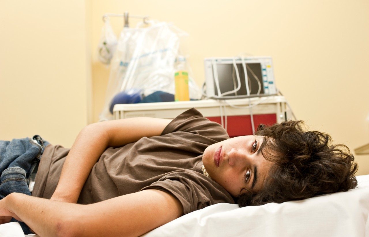 Teenage boy lying on a hospital bed