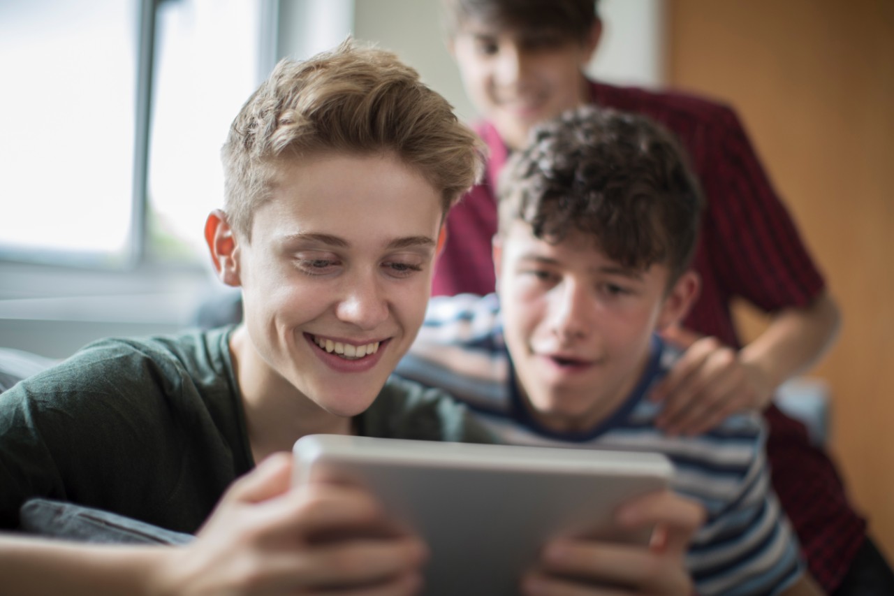 teenage boys playing on a tablet