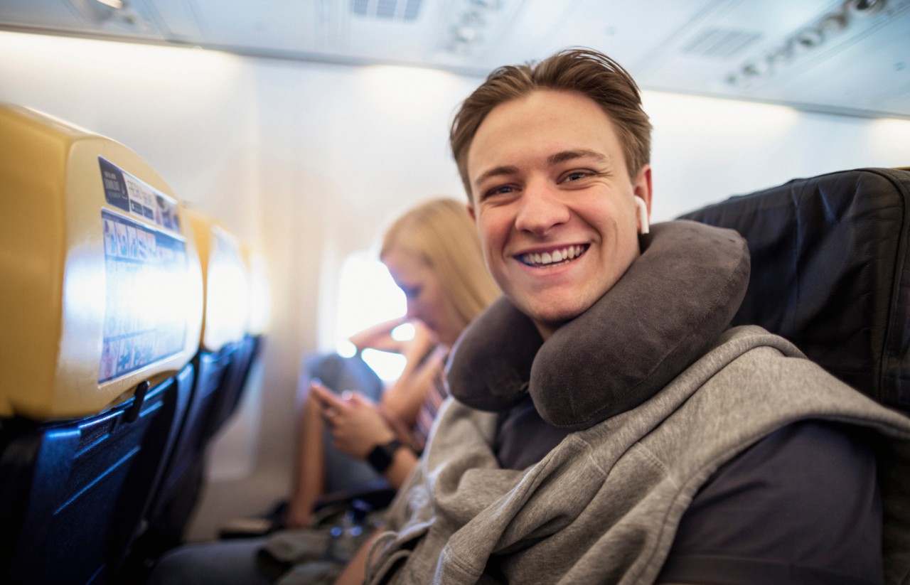 Young man sat in the aisle seat in a plane