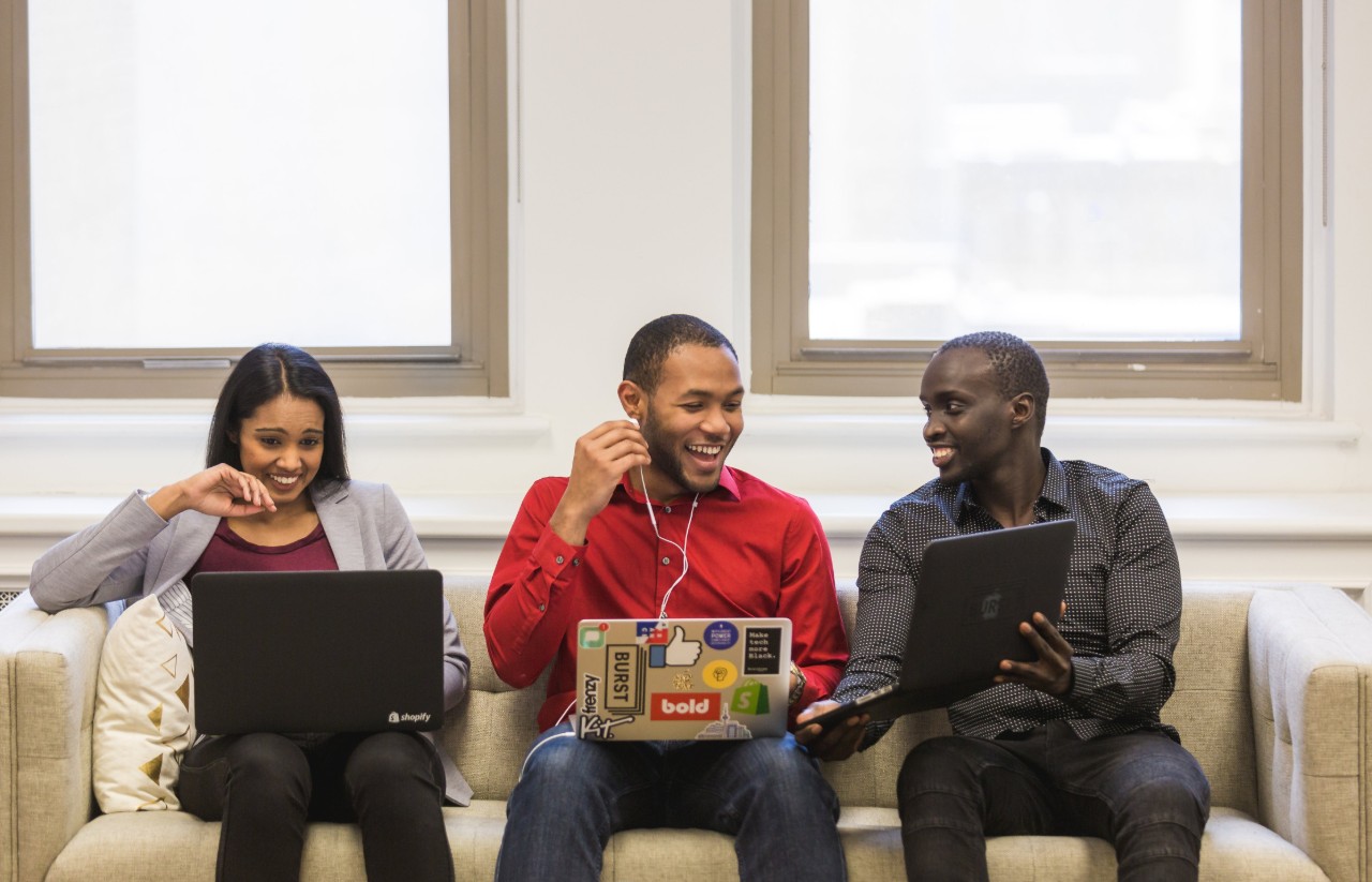 3 Students on a sofa with laptops