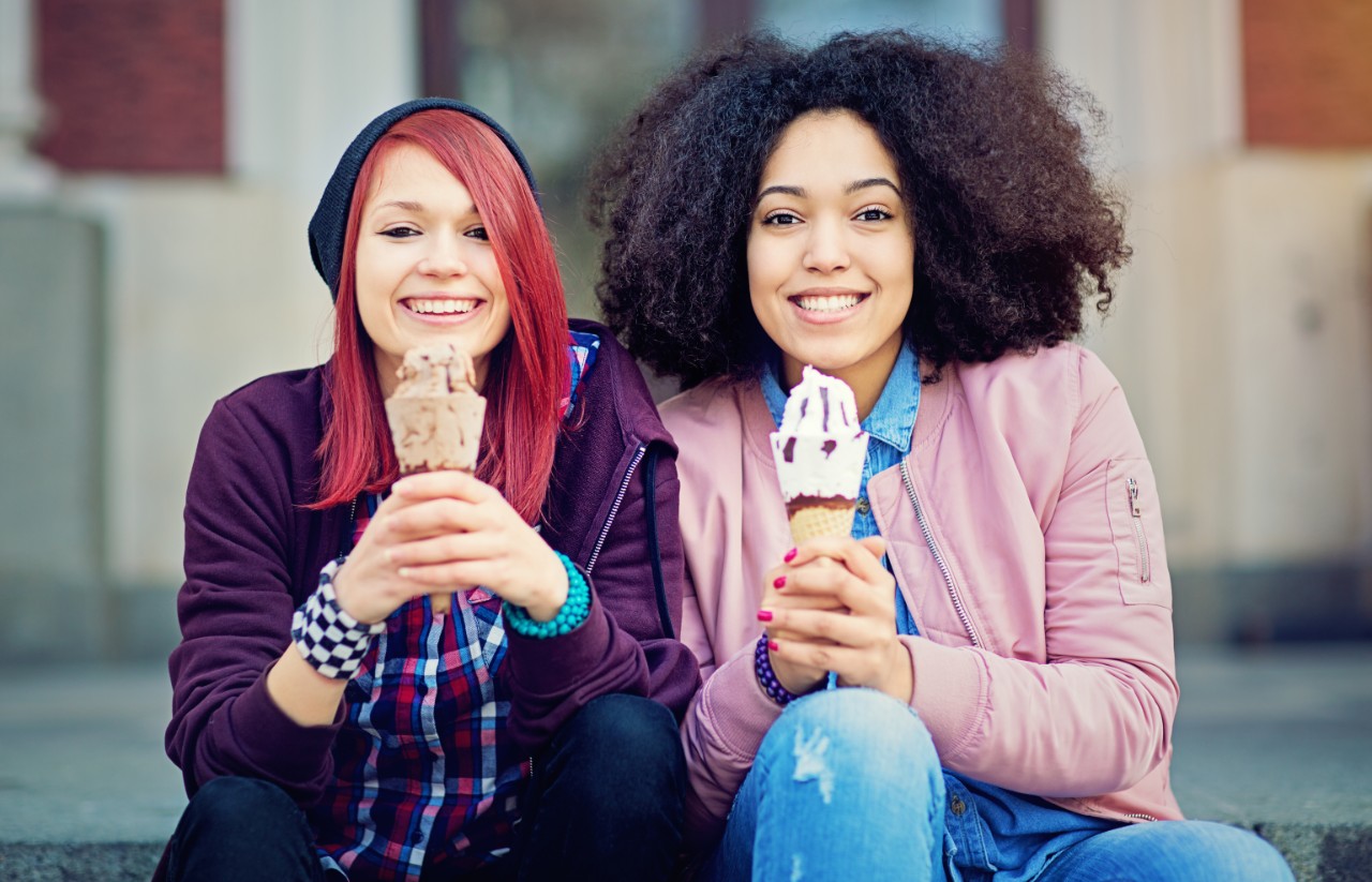 Girls sat together eating ice creams